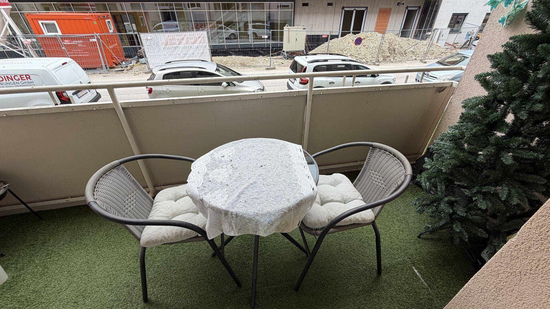 Kleiner Balkon mit Sitzgelegenheiten und Blick auf die Umgebung, ideal für entspannte Momente.