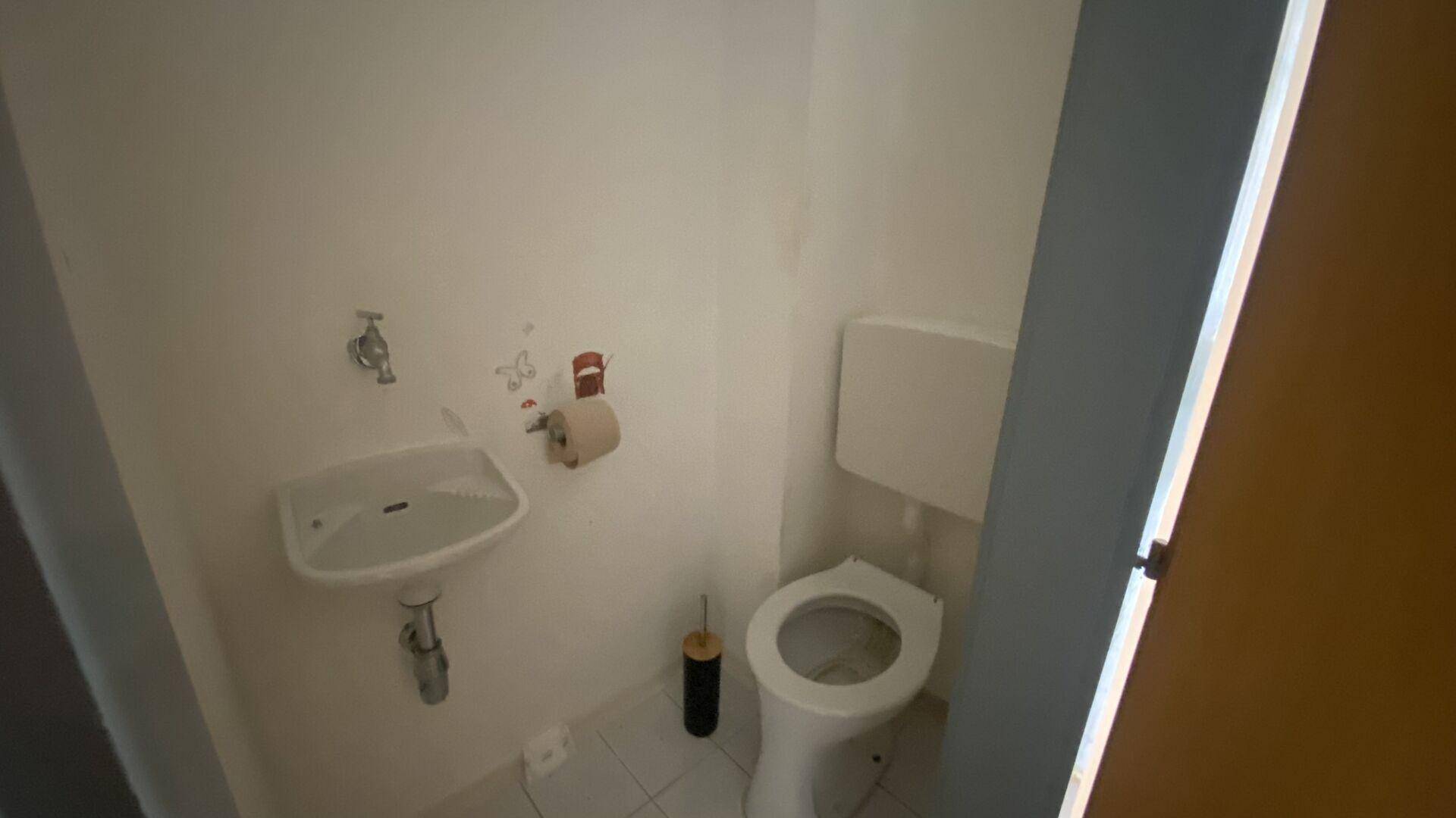 Kleines Gäste-WC mit Toilette und Handwaschbecken, praktisch und platzsparend gestaltet.