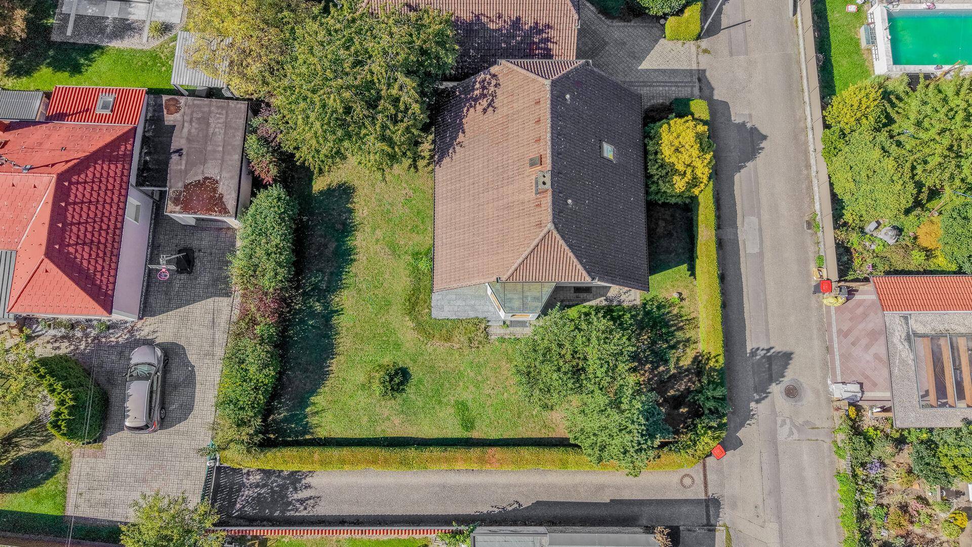 Vogelperspektive des Grundstücks, die das Dach und die Gartenanlage detailliert zeigt.