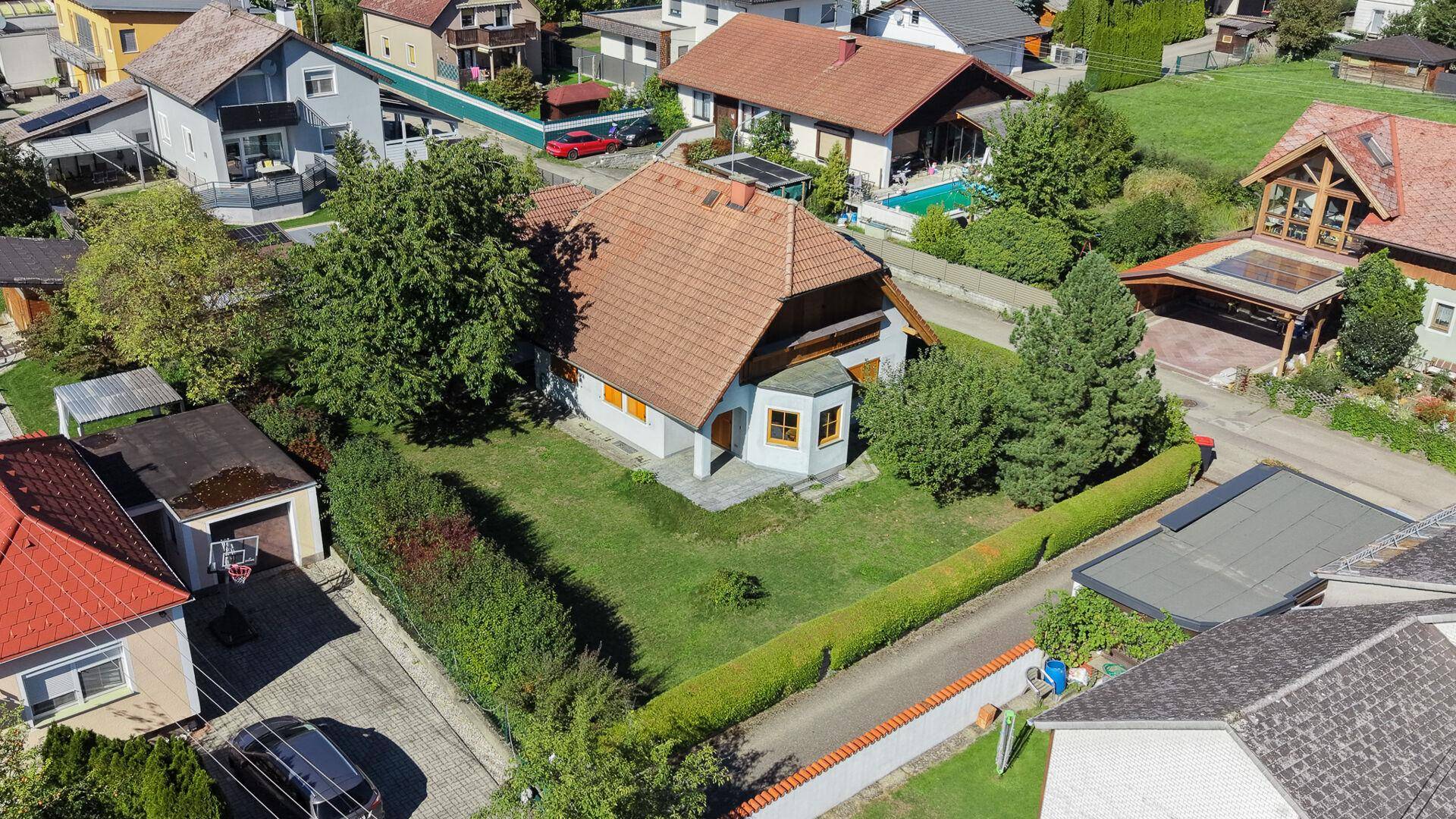 Weitläufige Luftaufnahme des Anwesens mit Haus, Garten und der umliegenden Wohnsiedlung.