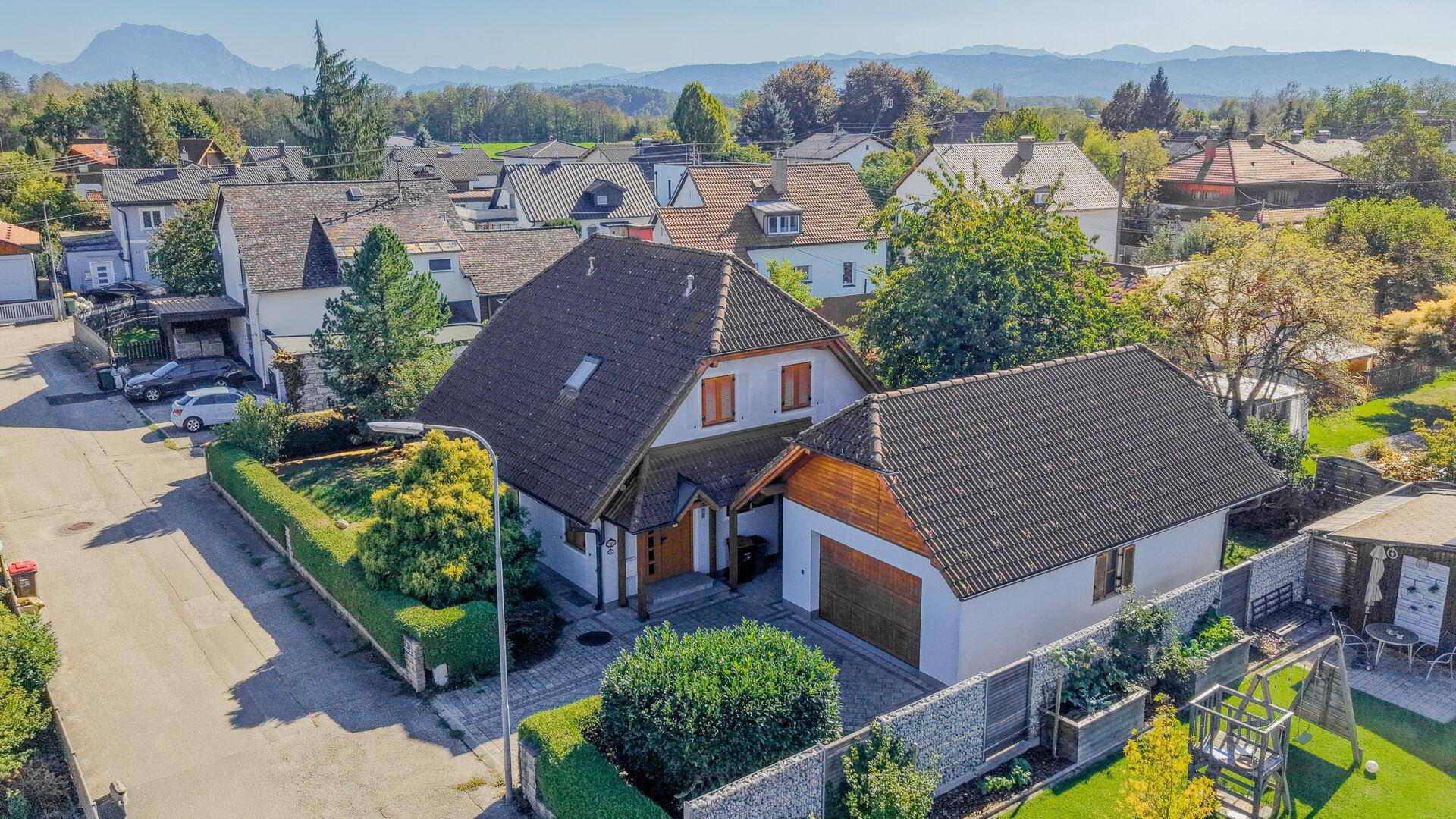 Luftaufnahme des Einfamilienhauses mit Garage, Garten und der umliegenden Wohngegend.