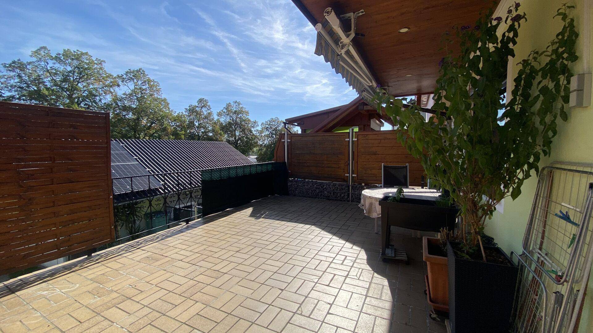 Geräumige gepflasterte Terrasse mit Sitzgelegenheiten und Blick auf die Umgebung.