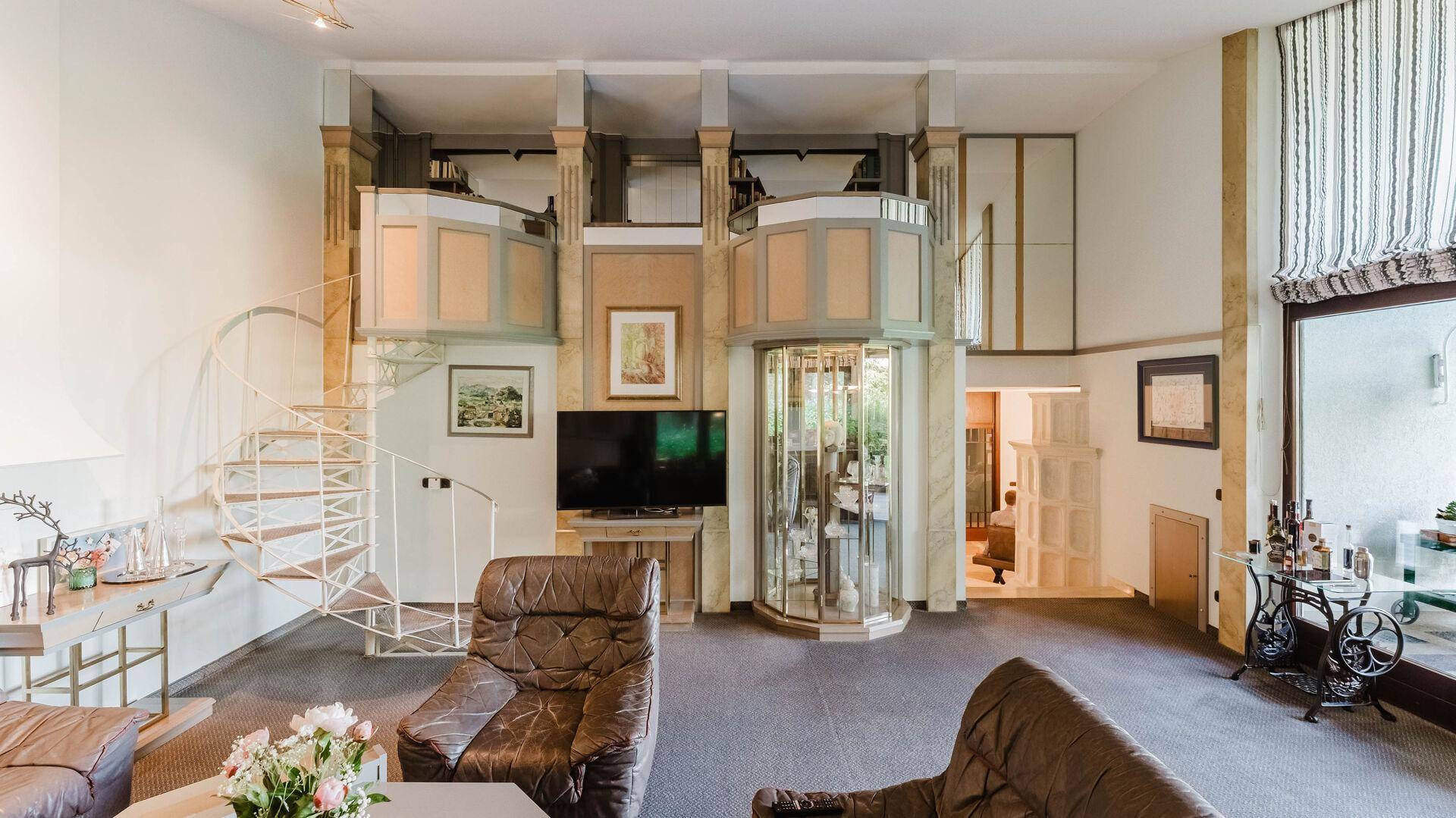 Helles Wohnzimmer mit Wendeltreppe, Teppichboden und dekorativen Elementen.