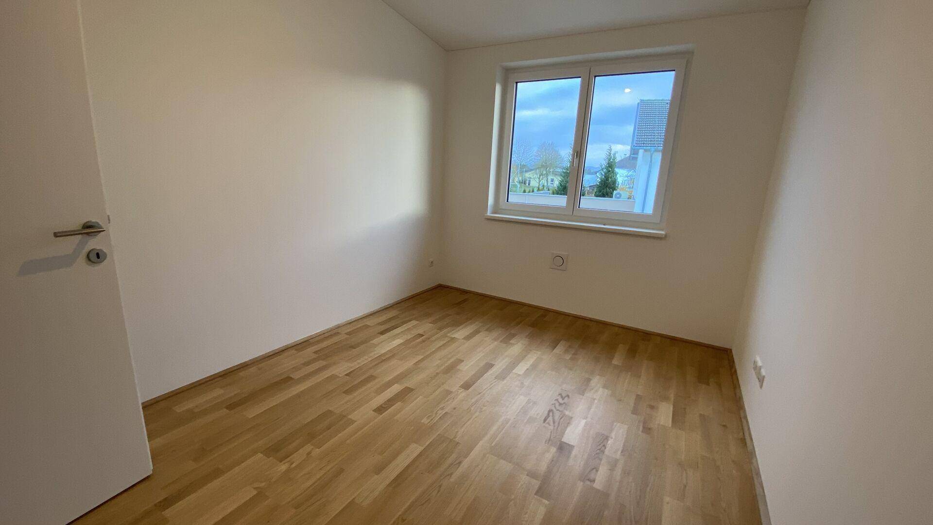 Weiteres helles Zimmer mit Parkettboden und Fenster, vielseitig nutzbar.