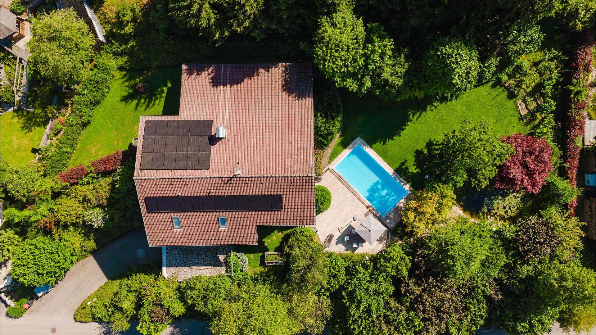 Vogelperspektive des Anwesens mit Haus, Pool und großem Garten.
