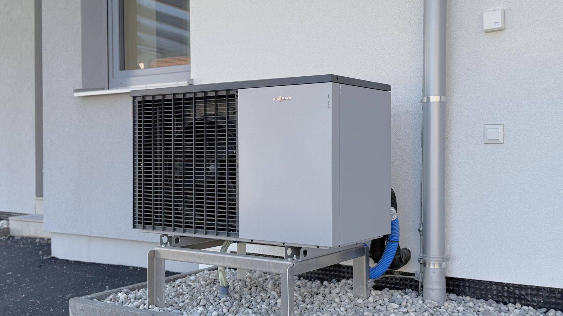 Eine moderne Wärmepumpe an der Außenwand des Hauses, die für effiziente Heizung sorgt.