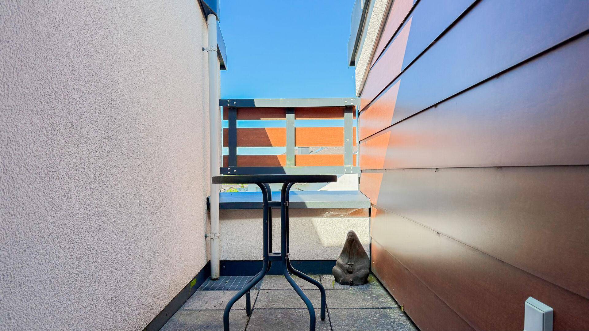 Kleiner, privater Balkon mit Tisch, perfekt für eine Tasse Kaffee am Morgen.