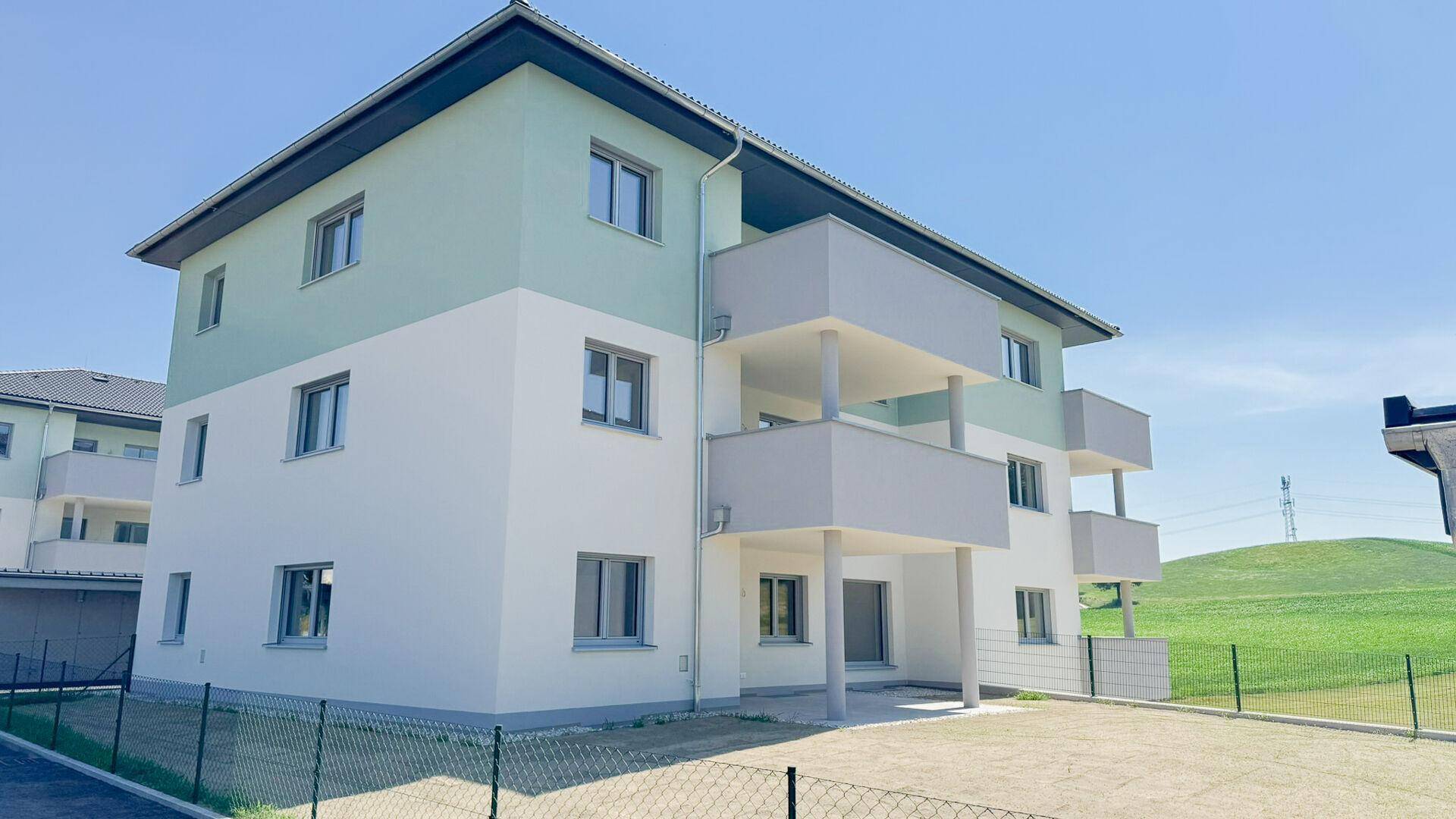 Neubau-Wohngebäude mit moderner Architektur, Balkonen und einer hellen Fassadengestaltung.