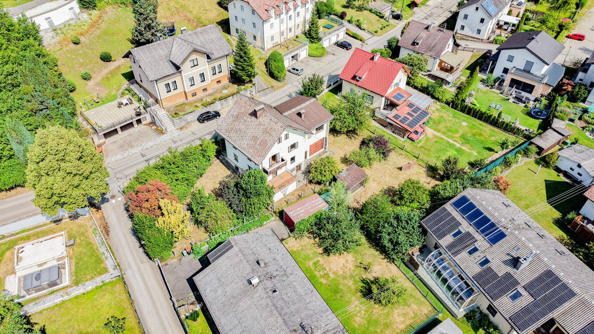 Weitläufige Luftaufnahme des Anwesens und der umliegenden Wohngegend mit vielen Gärten.