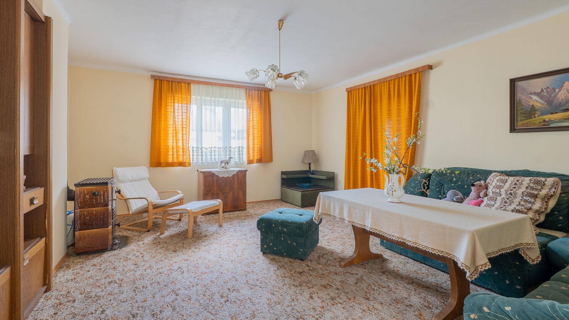Gemütliches Wohnzimmer mit Teppichboden, Sofa und traditioneller Einrichtung.
