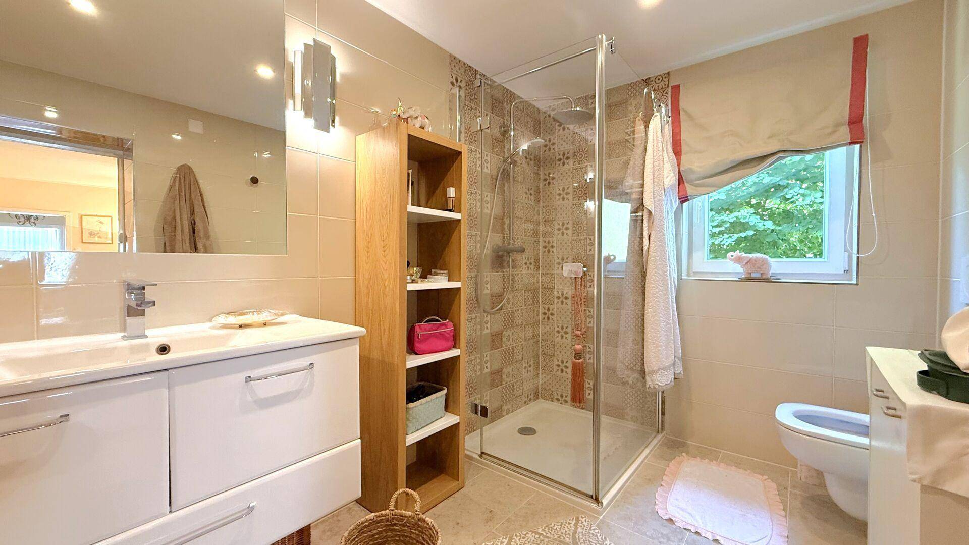 Modernes Badezimmer mit begehbarer Dusche, großformatigen Fliesen und Fenster.