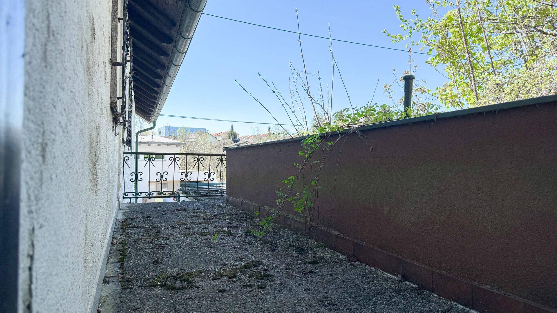 Balkon mit Metallgeländer und Blick auf die Umgebung, mit einfacher Gestaltung.
