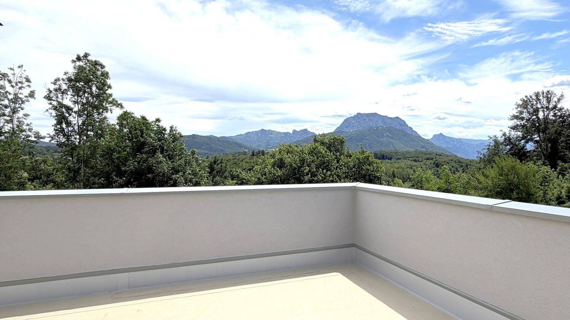 Weitläufige Terrasse mit atemberaubendem Panoramablick auf die umliegende Berglandschaft und grüne Wälder.