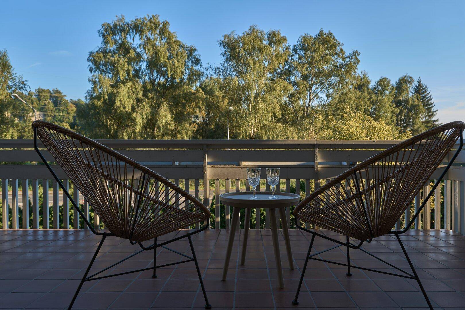 Balkon mit gemütlichen Sitzgelegenheiten und einem weiten Blick ins Grüne.