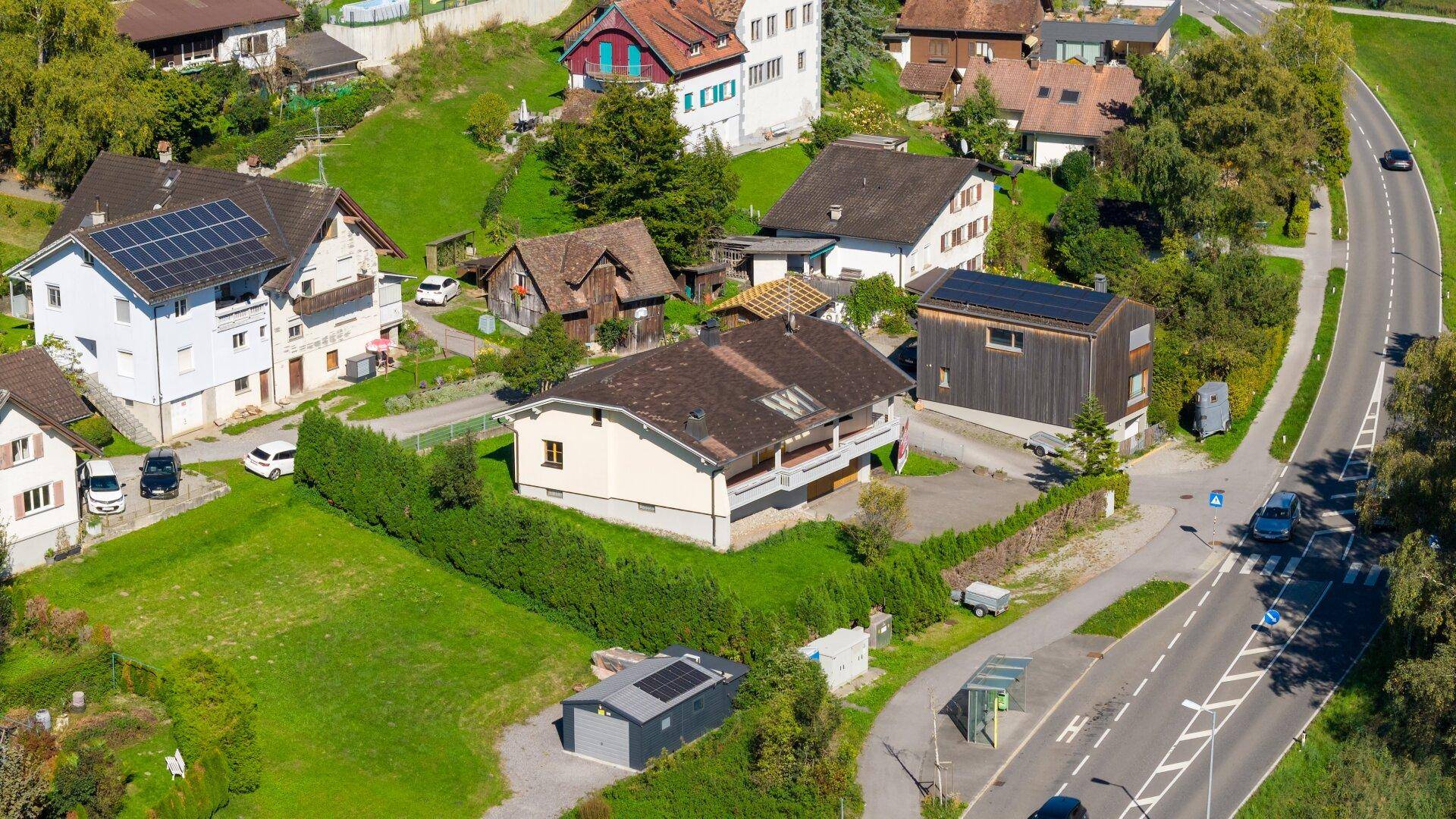 Weitläufige Luftaufnahme der Wohnsiedlung mit dem Objekt und der Zufahrtsstraße.