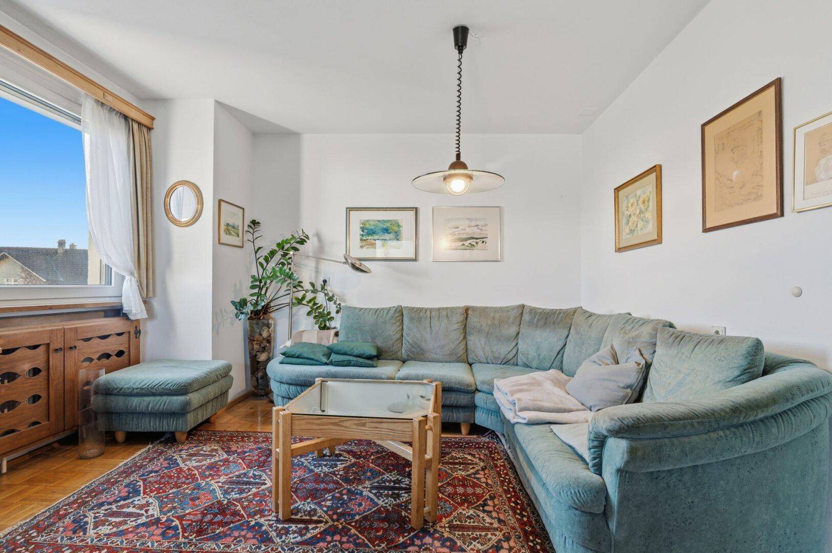 Gemütliches Wohnzimmer mit einem großen Ecksofa, Teppich und Holzboden.