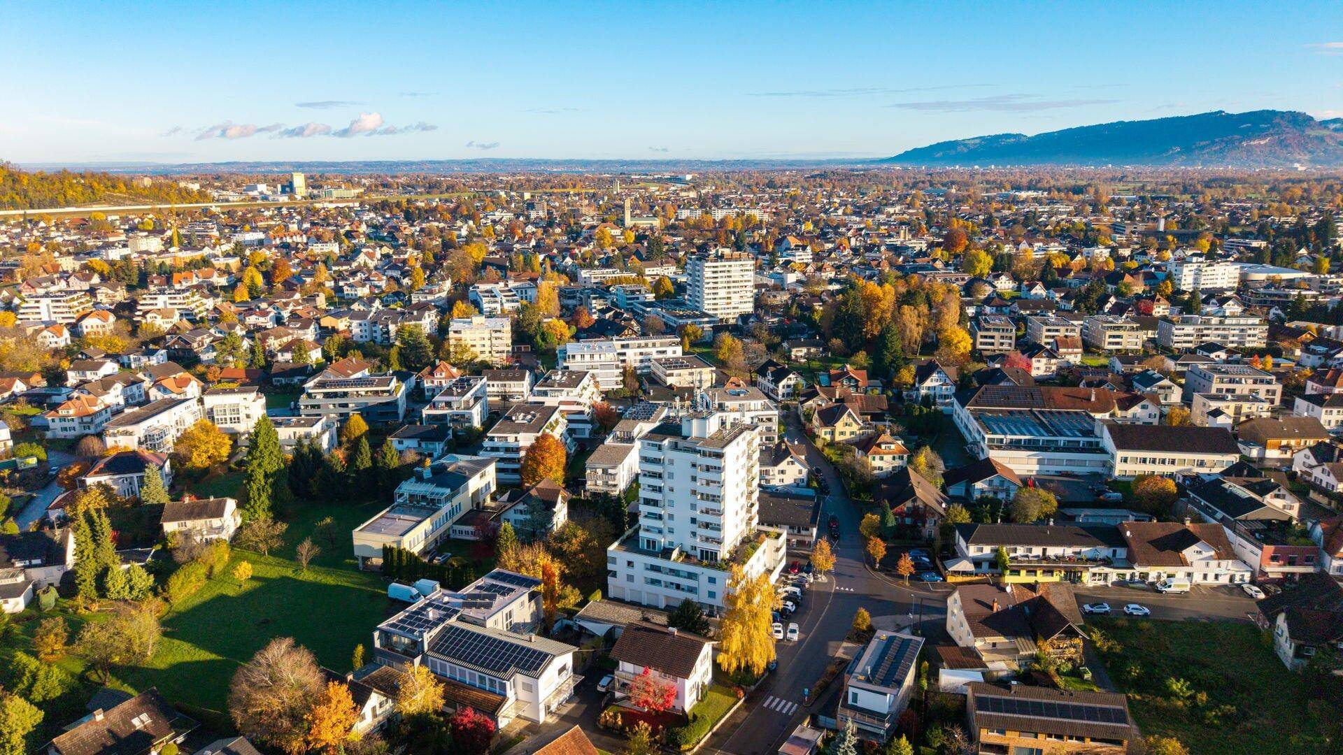 Überblick über die weitläufige Wohnsiedlung mit dem zentralen Hochhaus und vielen Grünflächen.