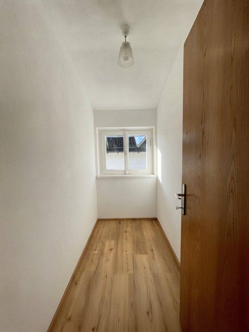 Kleiner, heller Raum mit Laminatboden und Fenster, ideal als Büro oder Abstellraum.