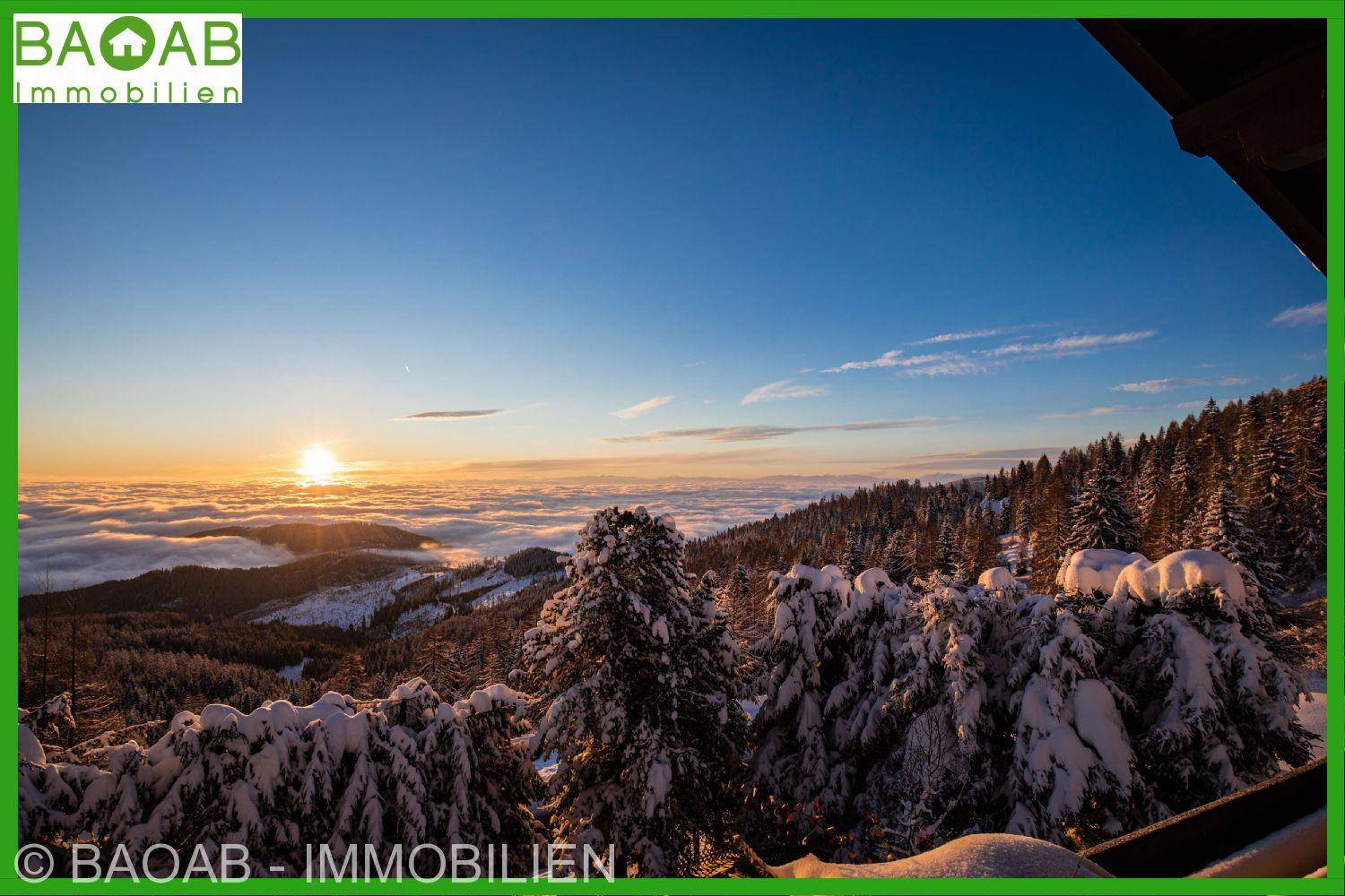 Spektakulärer Sonnenuntergang über einer verschneiten Berglandschaft mit dichten Wäldern.