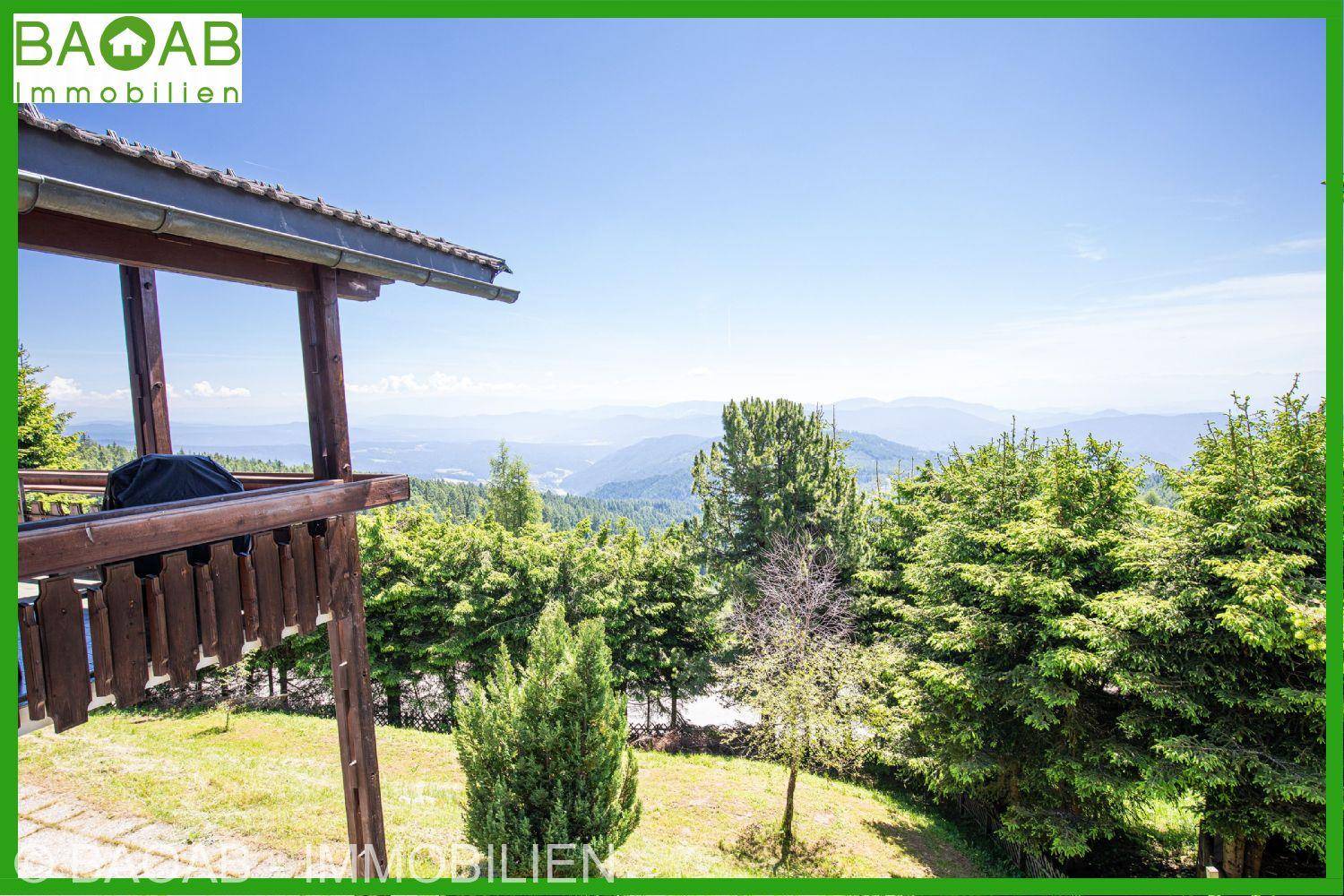 Holzbalkon mit weitem Blick über die bewaldeten Berge und Täler.
