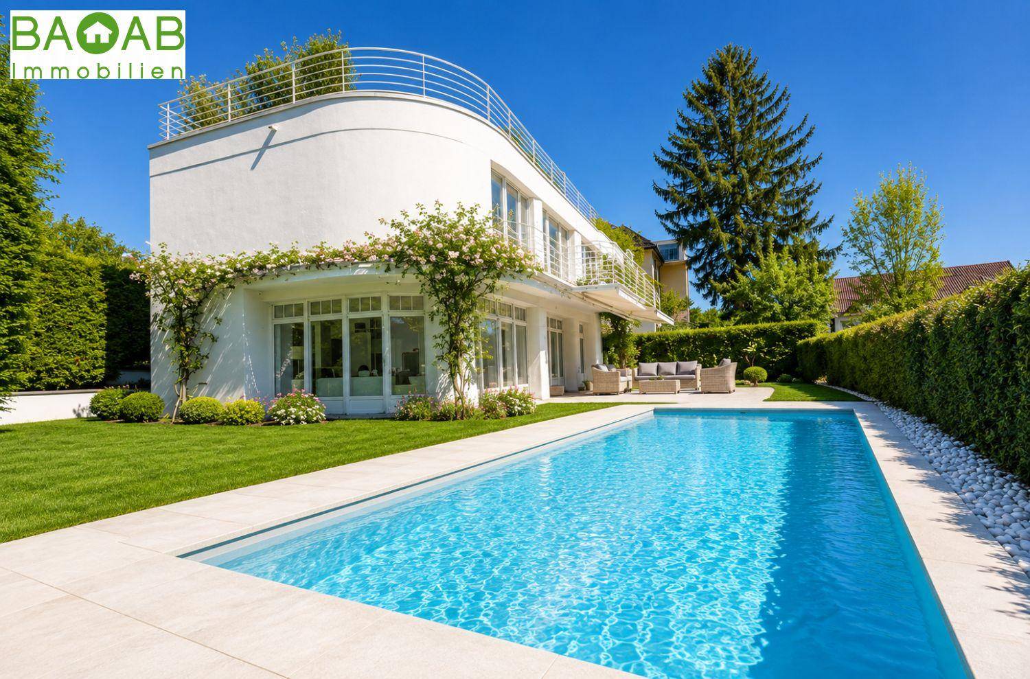 Moderne weiße Villa mit großem Außenpool, gepflegtem Rasen und sonniger Terrasse.