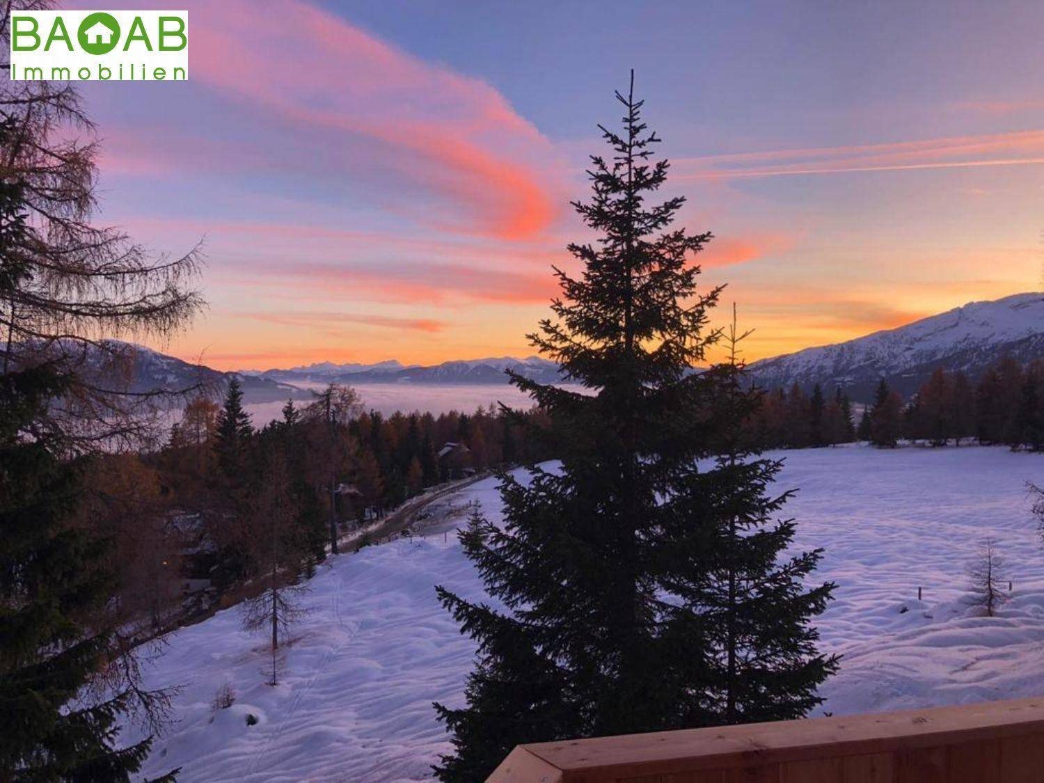 Malerische Winterlandschaft bei Sonnenuntergang mit schneebedeckten Feldern und farbenprächtigem Himmel.
