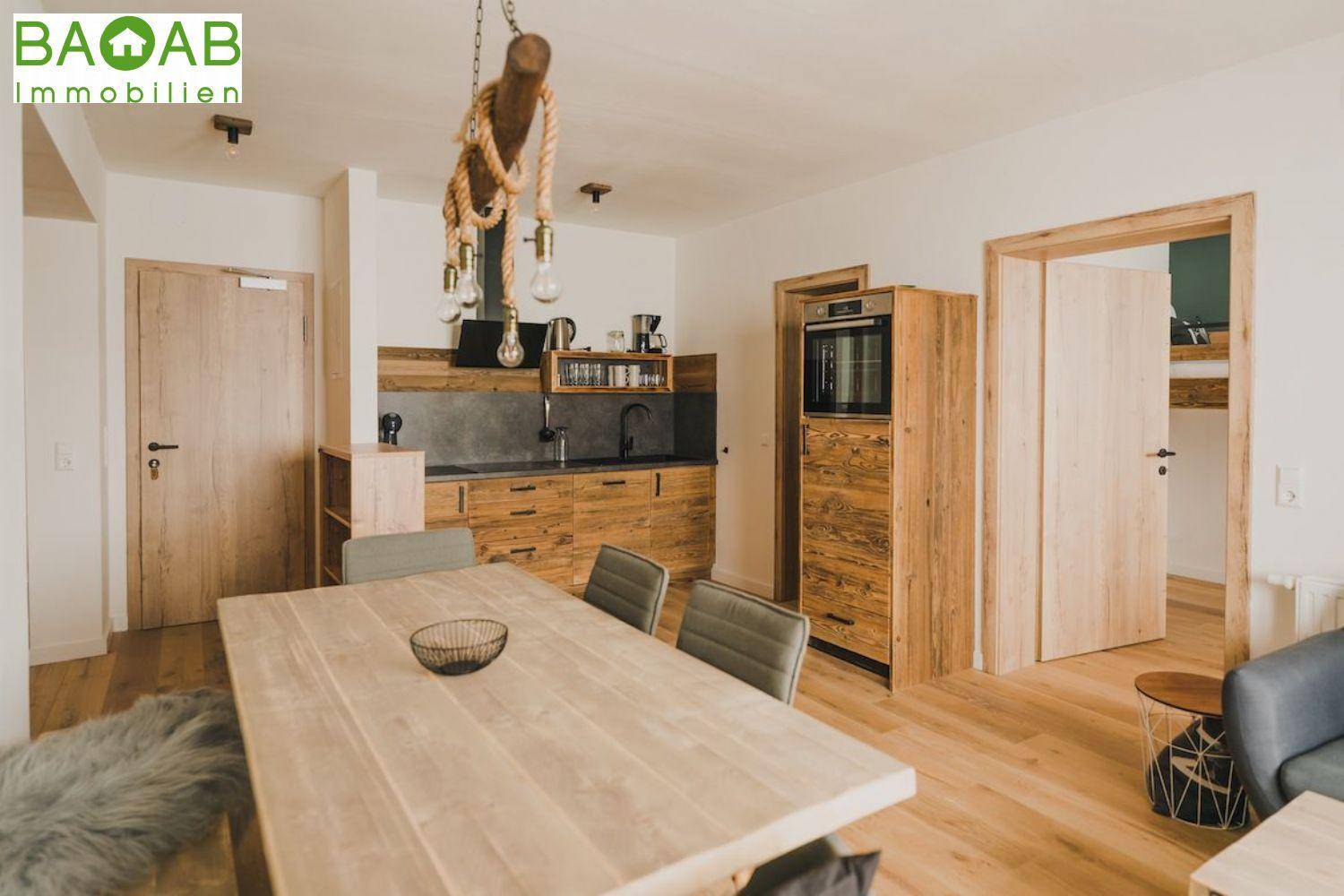 Moderne Küche mit Holzelementen, integrierten Geräten und einem Essbereich.