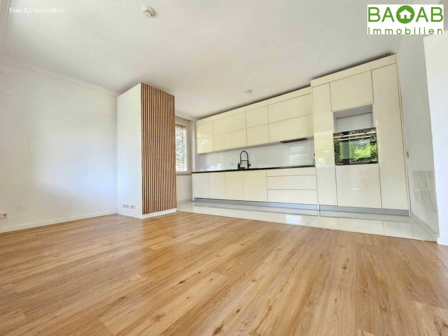 Moderne, offene Küche mit glänzenden Fronten und Holzboden, integriert in einen hellen Wohnbereich.