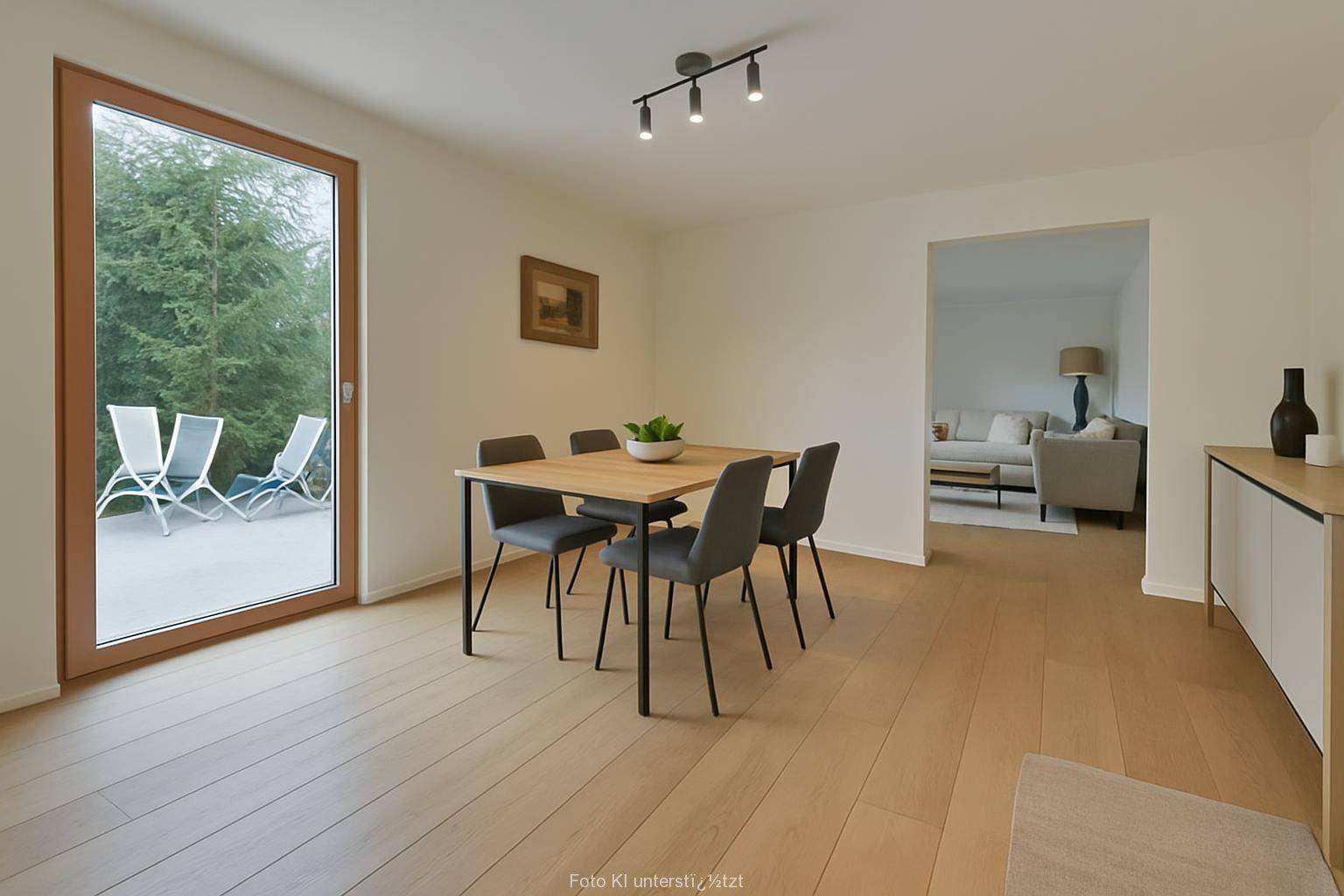 Heller Essbereich mit Holzboden, großem Fenster und Blick auf eine Terrasse im Grünen.