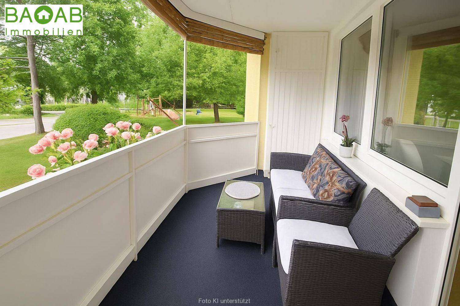 Gemütlicher Balkon mit Sitzgelegenheiten und Blick ins Grüne mit Spielplatz.