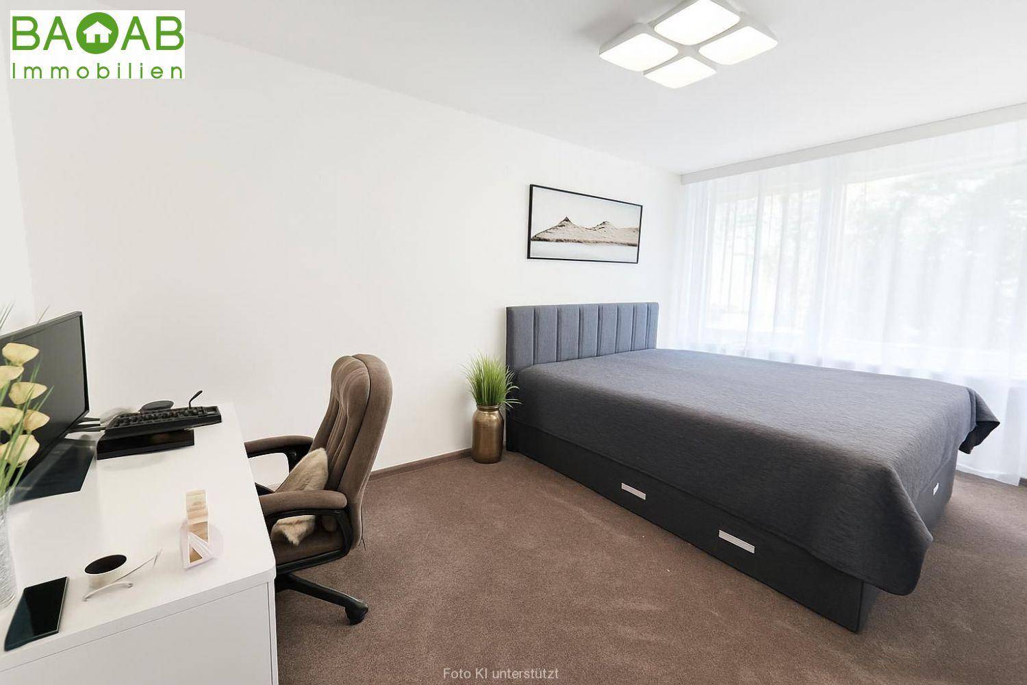 Schlafzimmer mit Teppichboden, Schreibtisch und Bett mit Stauraum unter dem Bett.