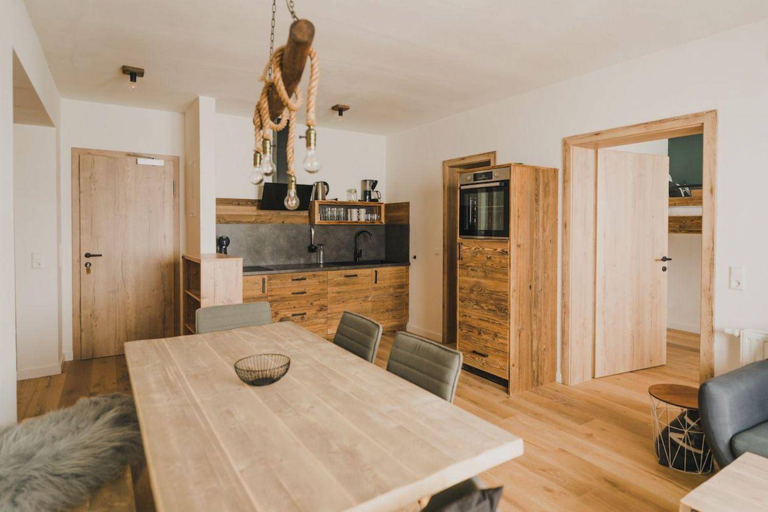 Offener Essbereich mit großem Holztisch und angrenzender Küche im Landhausstil.