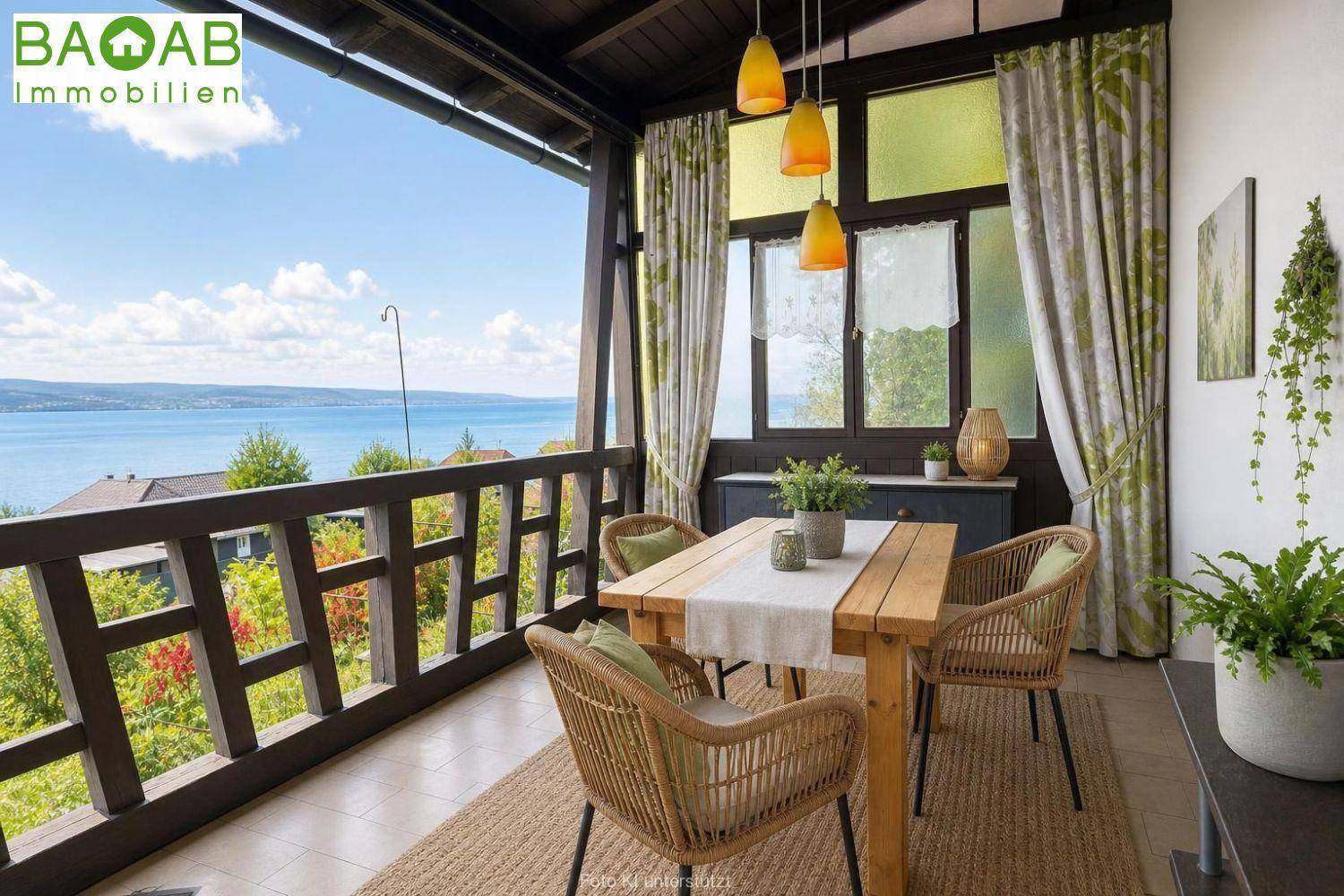 Geräumiger Balkon mit Esstisch und Stühlen, bietet einen atemberaubenden Blick auf den See und die Berge.