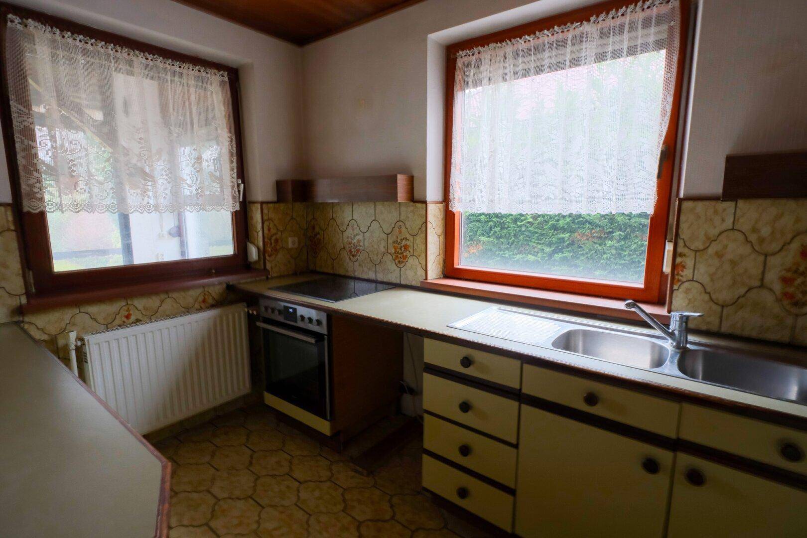 Kleine Küche im Vintage-Stil mit Einbauschränken, Herd und Spüle.