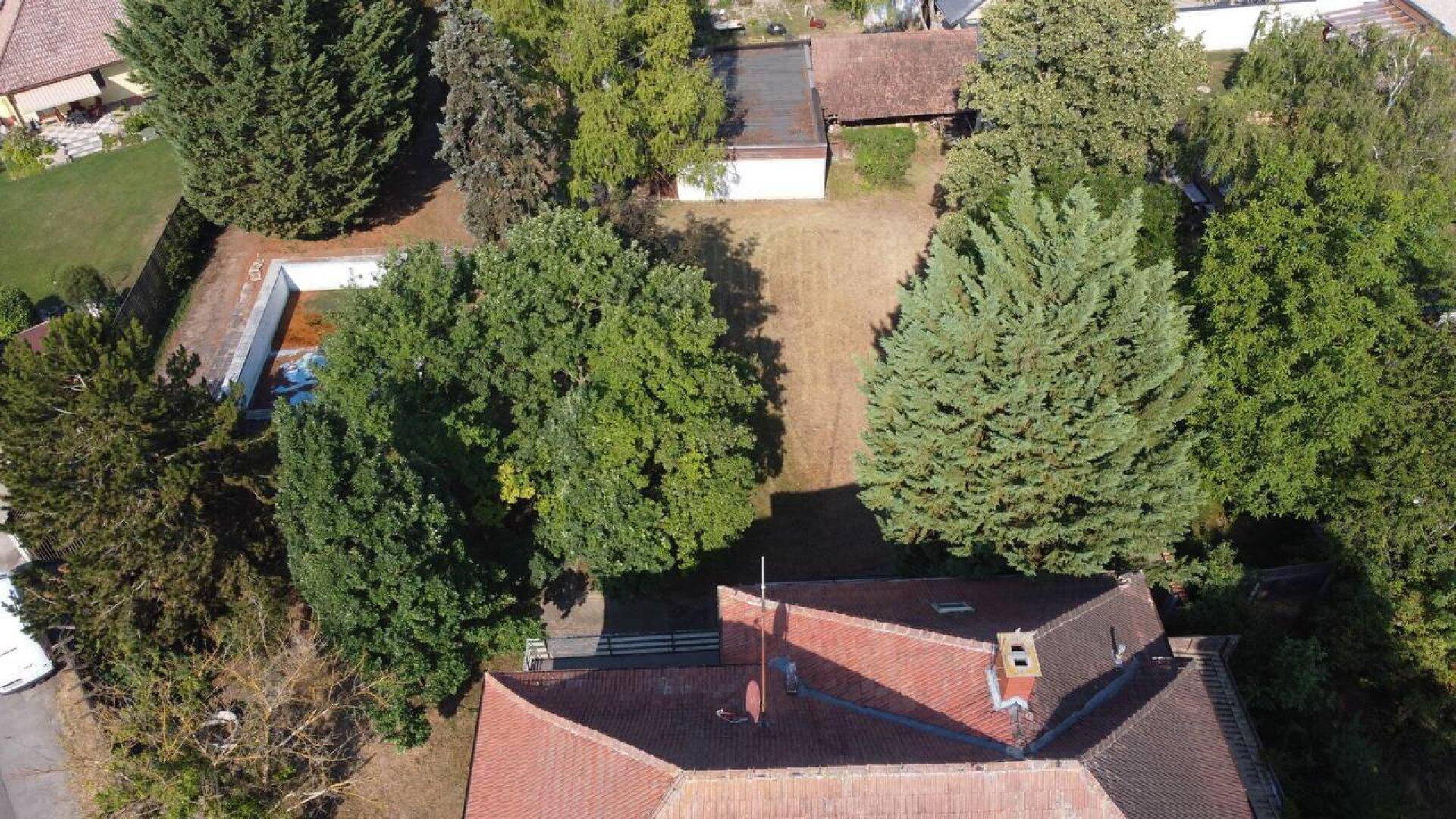 Luftaufnahme des Anwesens mit Hauptgebäude, großem Gartenbereich und einem Schwimmbecken.