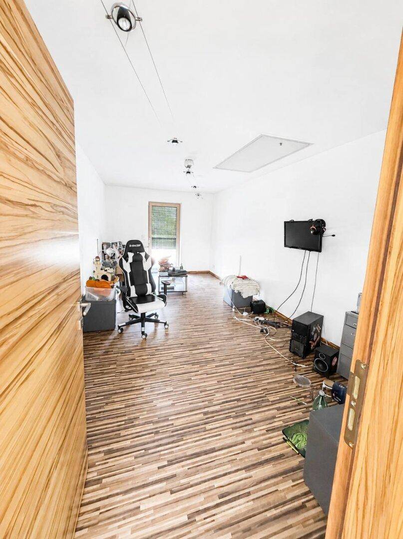 Arbeitszimmer mit Laminatboden, Schreibtischstuhl und Blick auf den Raum.