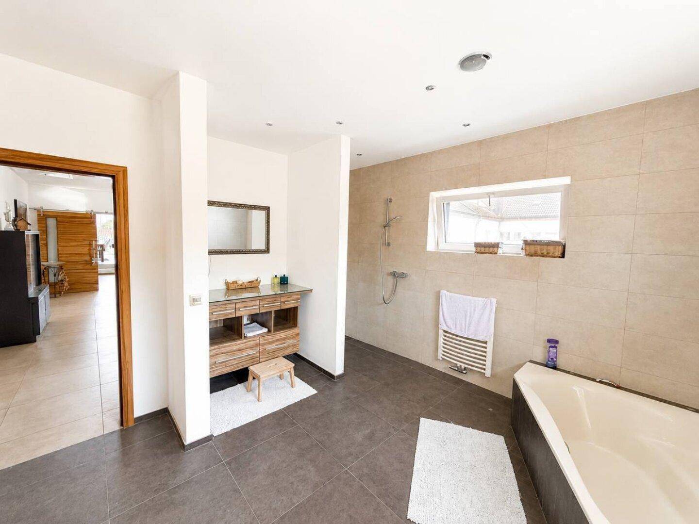 Modernes Badezimmer mit Einzelwaschbecken, Dusche und Badewanne.