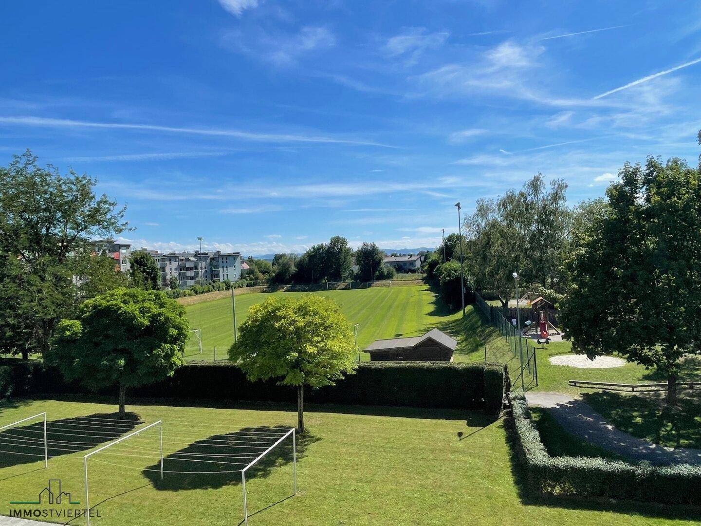 Ausblick ins Grüne zum Spielplatz und Sportplatz