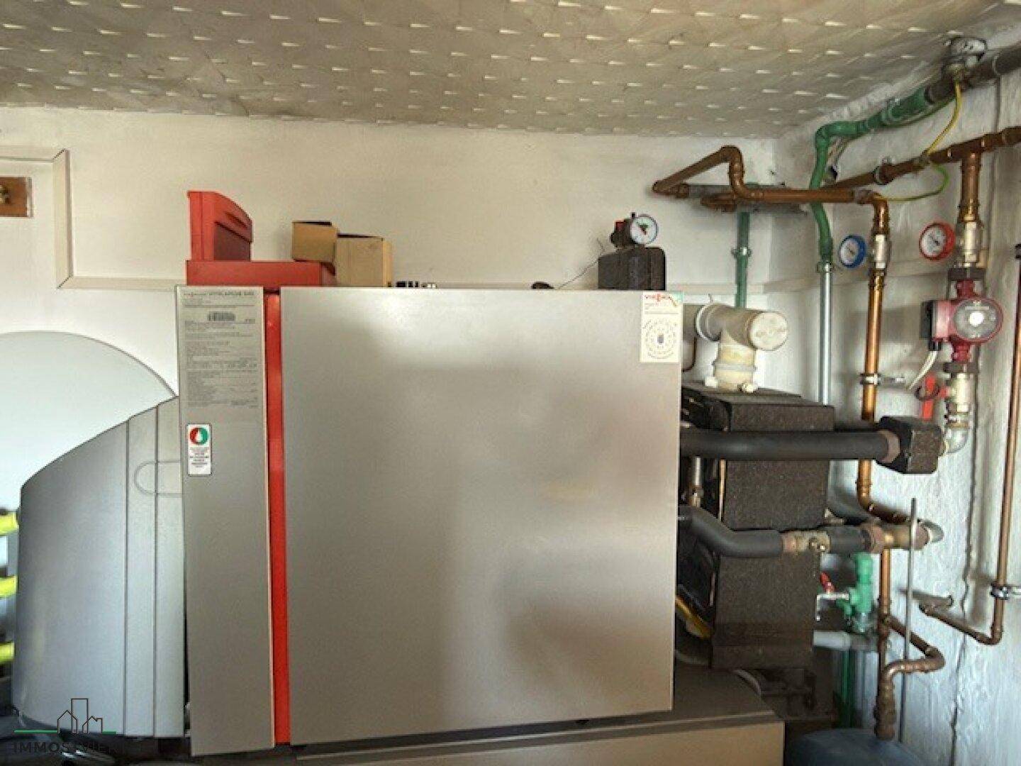 Heizungsraum mit moderner Heizungsanlage und sichtbaren Rohrleitungen.