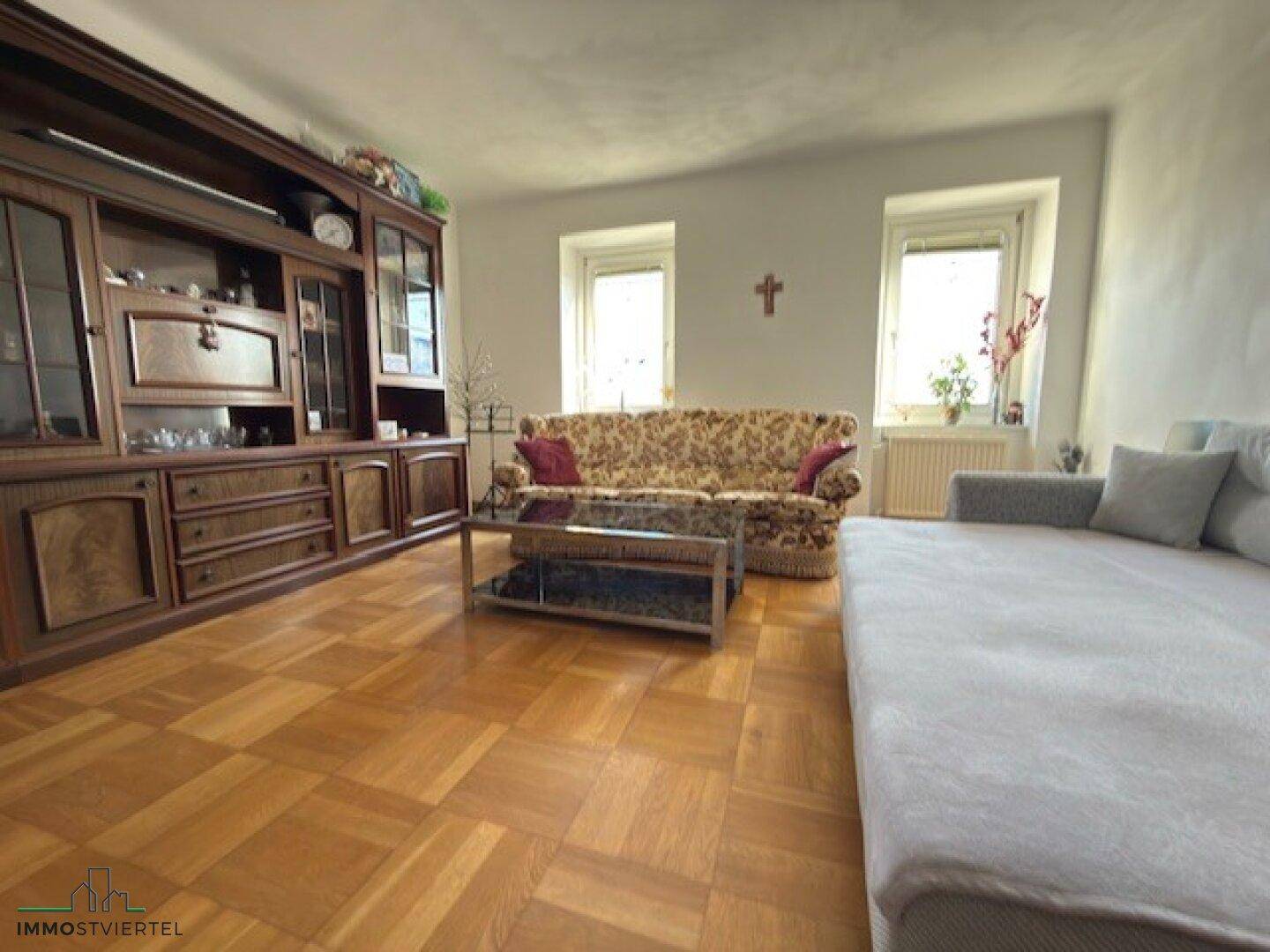 Gemütliches Wohnzimmer mit Parkettboden, traditionellen Möbeln und Sofa.