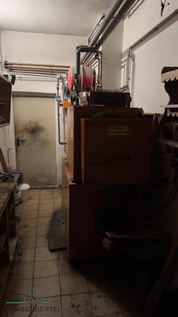 Heizungsraum mit einem großen Viessmann-Boiler und sichtbaren Rohren, in einem funktionalen Zustand.