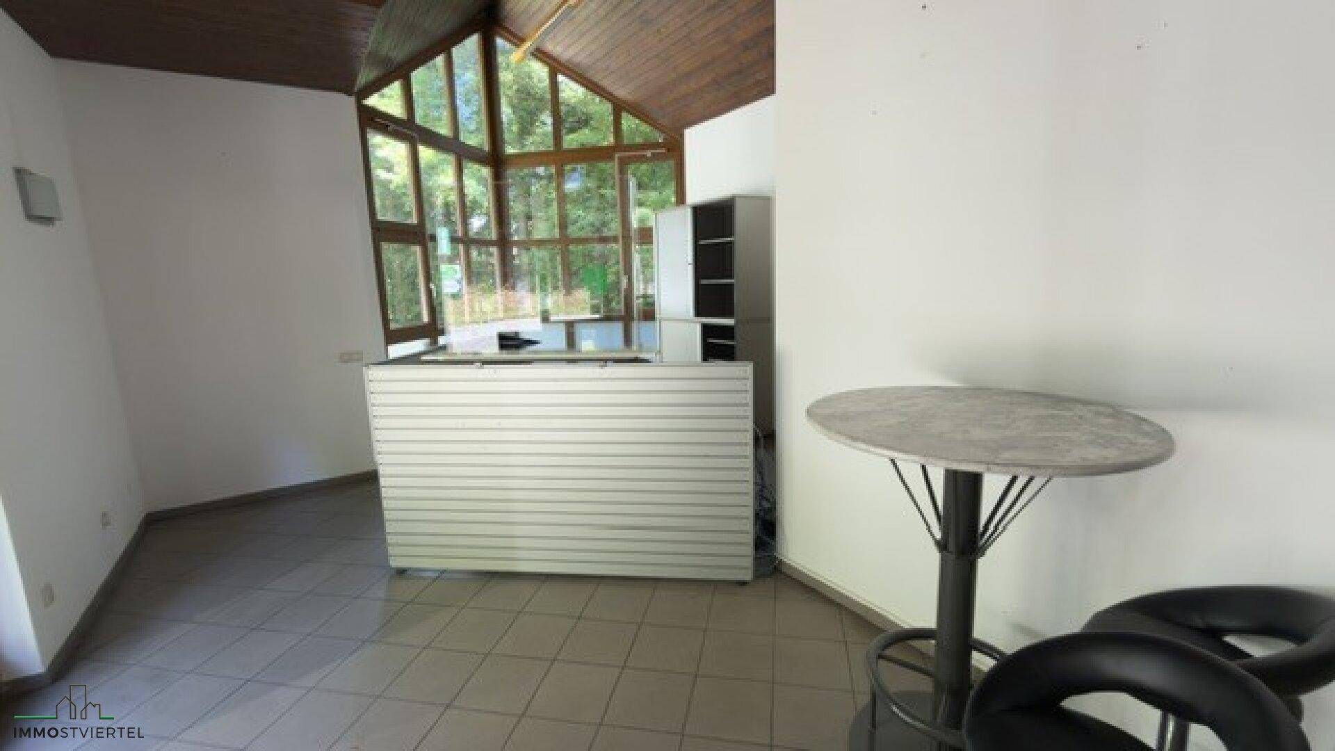 Geräumiger Innenraum mit Theke, Stehtisch und Hockern, ideal für einen Imbiss oder Cafébetrieb.