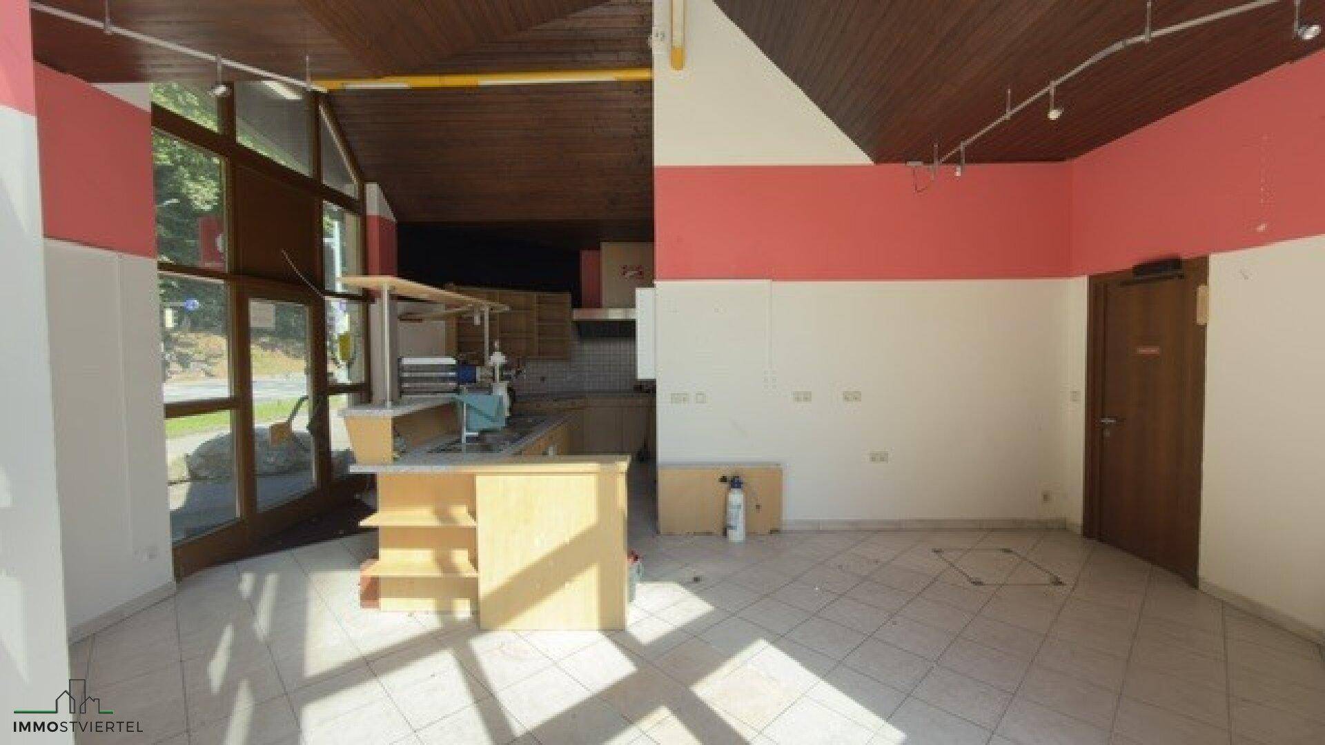 Innenansicht des Servicebereichs mit Theke, Fliesenboden und Holzdecke, bereit zur Einrichtung.