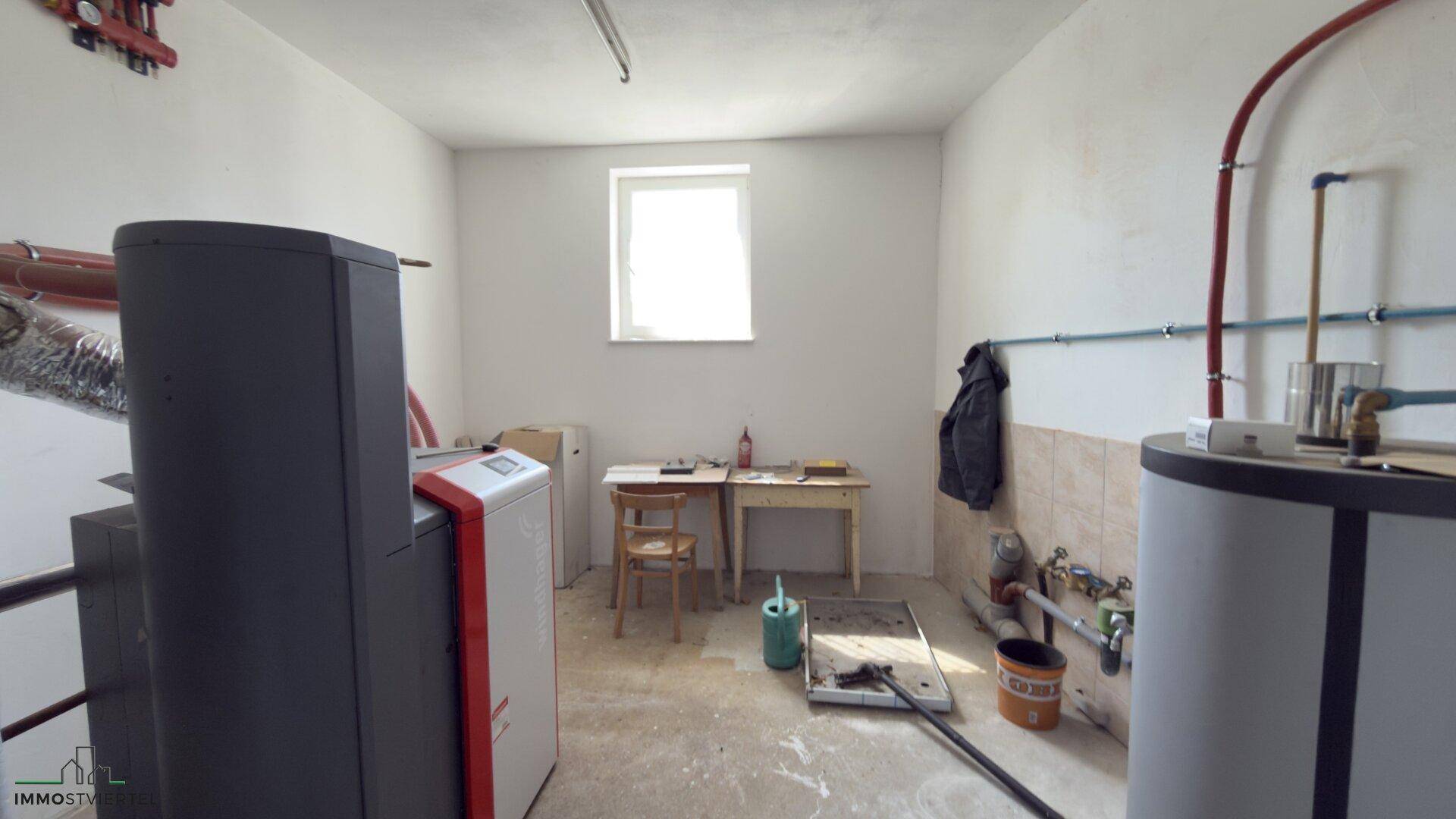 Heizungsraum mit modernen Heizkesseln und sichtbaren Rohrleitungen.