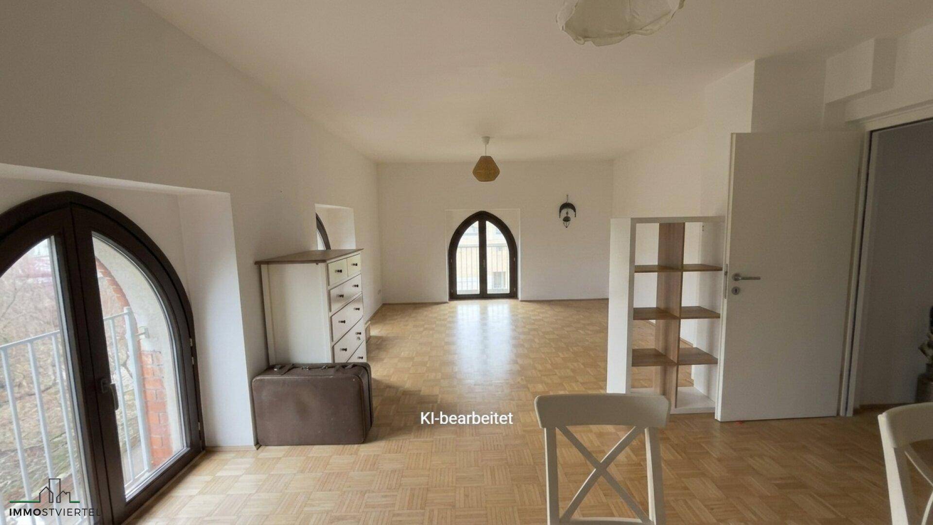 Helles Wohnzimmer mit Parkettboden, hohen Decken und großen Rundbogenfenstern, unmöbliert.
