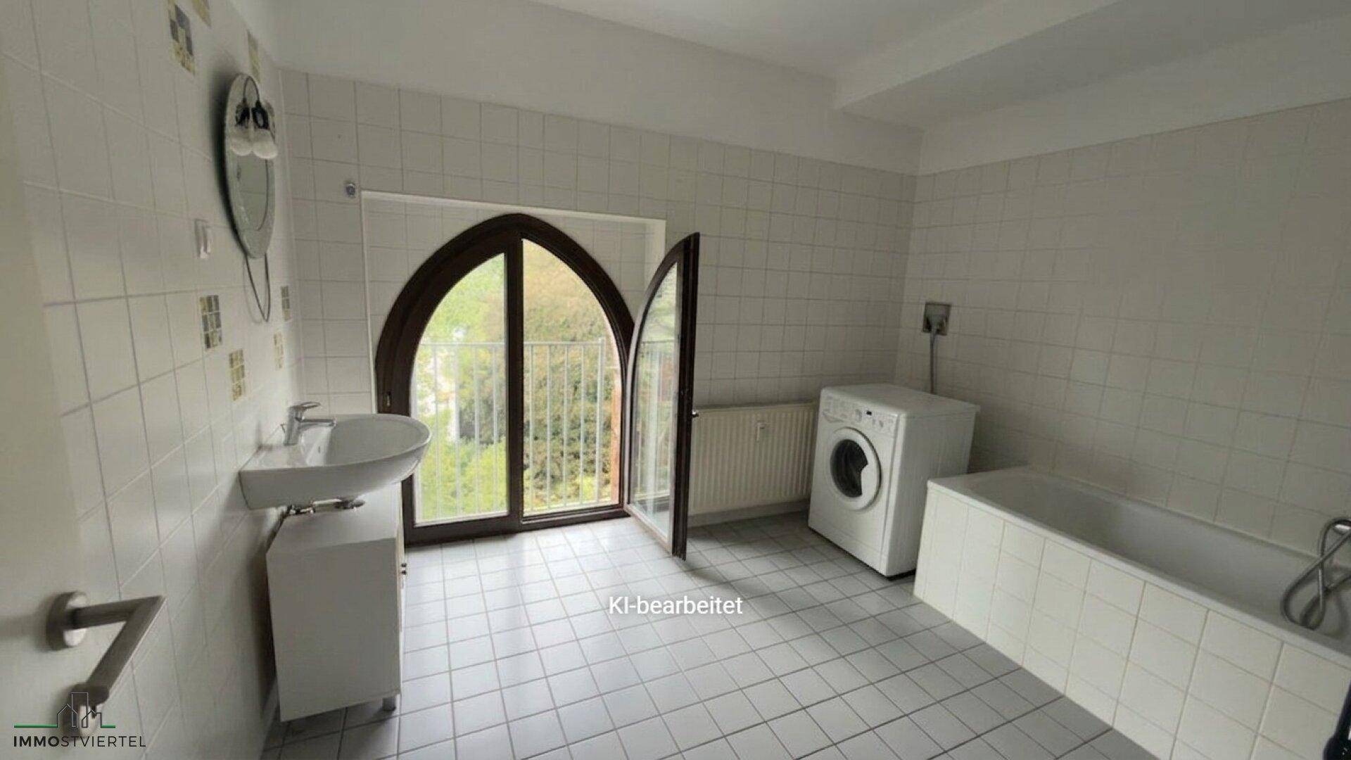 Geräumiges Badezimmer mit Badewanne, Waschbecken und Waschmaschine, hell gefliest und mit Fenster.