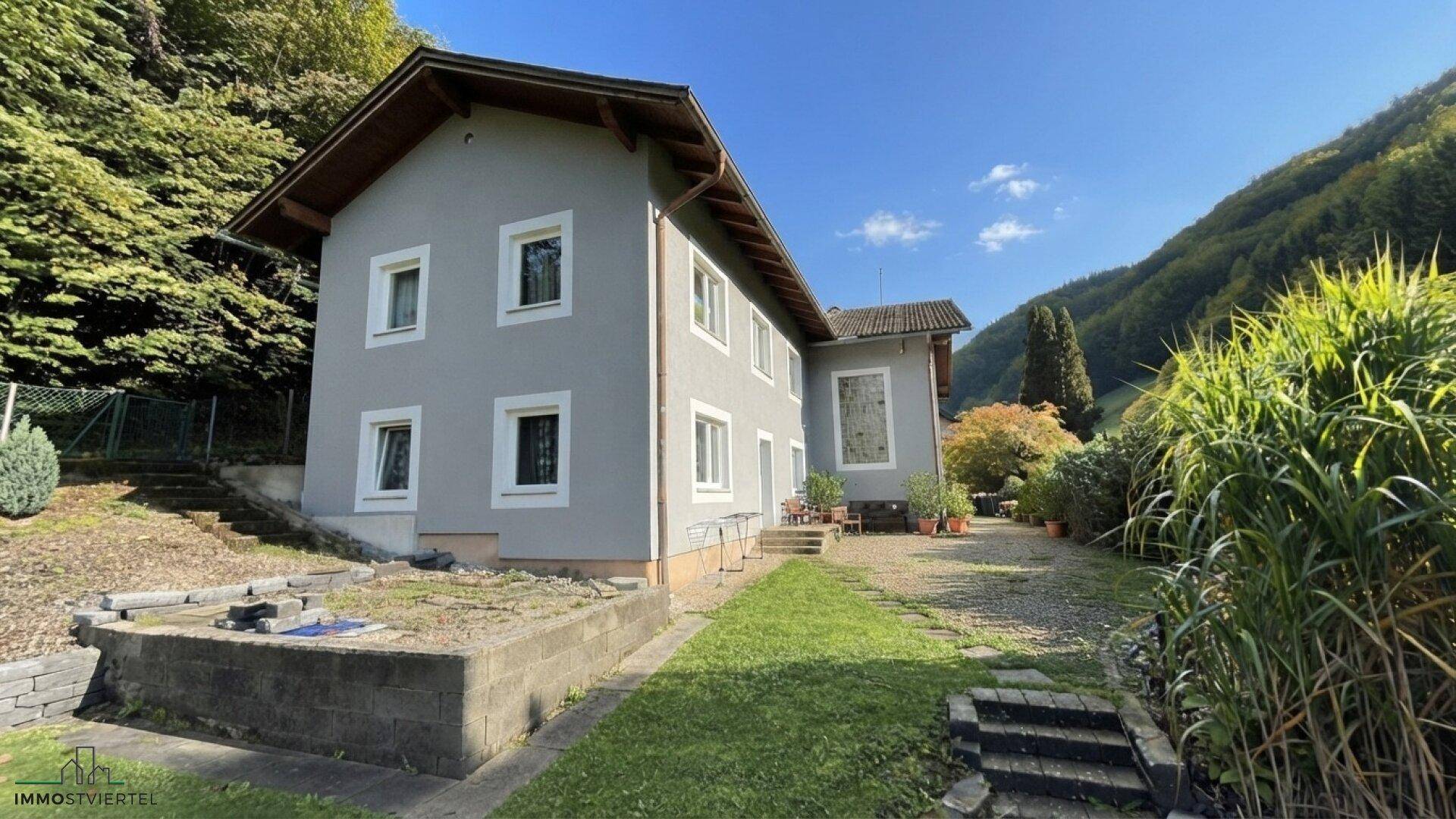 Rückansicht des Hauses mit Gartenbereich und Blick auf die umliegende Natur.