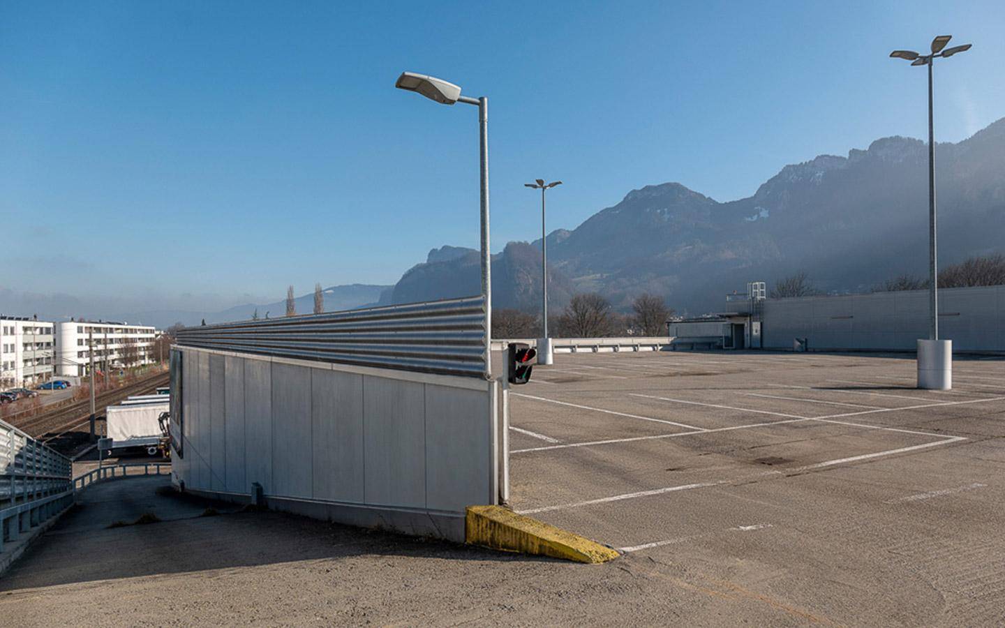 Großer Parkplatz auf dem Dach eines Gebäudes mit freiem Blick auf die umliegende Berglandschaft.