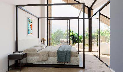 Modernes Schlafzimmer mit Himmelbett, großen Glasfronten und Blick in die Natur.