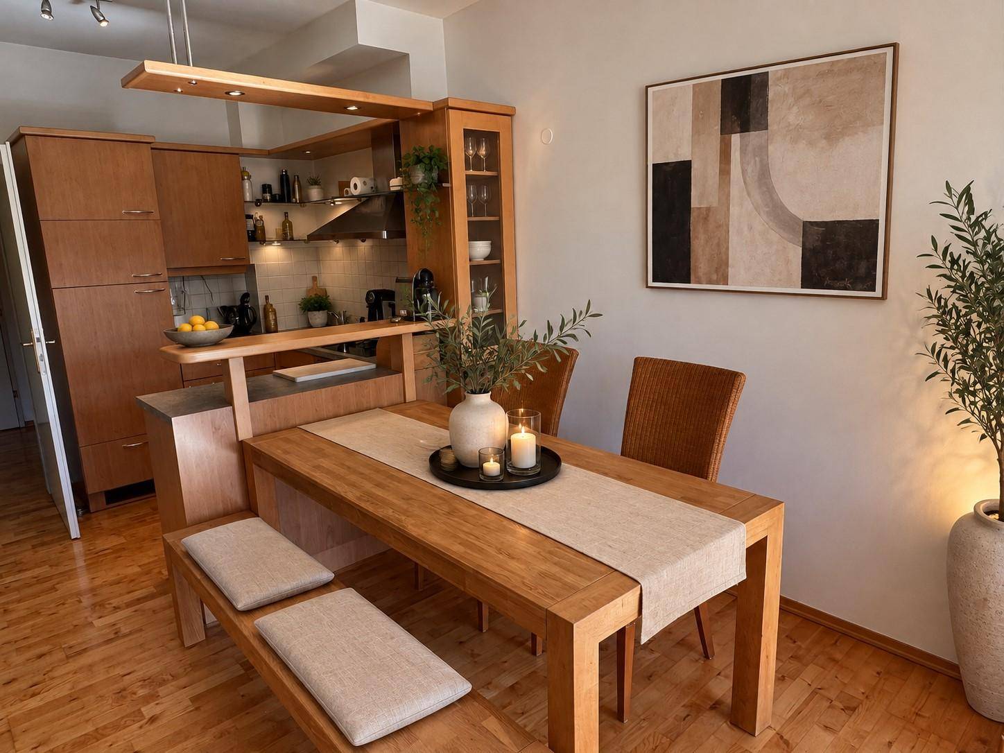 Offener Wohn-Essbereich mit Holztisch und integrierter Küche im Hintergrund, modern eingerichtet.